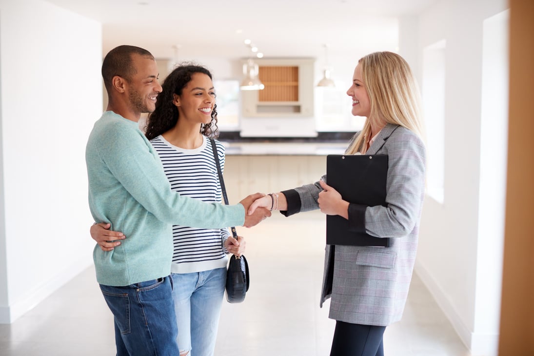 Female Realtor Shaking Hands with Couple