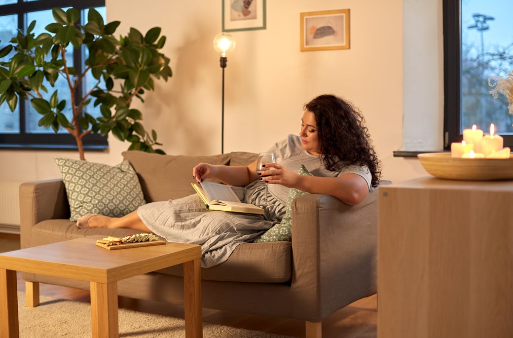 Woman Reading Book and Drinking Red Wine at Home